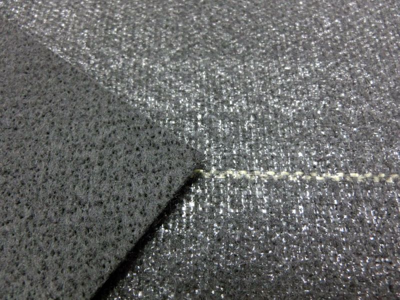 [シートの拡大]写真右側が表面、左側が裏面です。表面は、目の細かいポリプロピレン織布です。裏面は、ポリエステル不織布で、ハサミで切り込みを入れてもほつれ難いです。