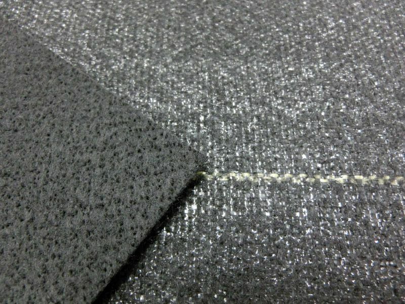 [シートの拡大]写真右側が表面、左側が裏面です。表面は、目の細かいポリプロピレン織布です。裏面は、ポリエステル不織布で柔軟性があり敷きやすいです。また、ハサミで切り込みを入れてもほつれ難いです。